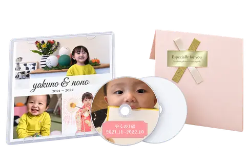 子どもの写真を印刷したケースとディスク、白いディスク、ピンクのギフトラッピング