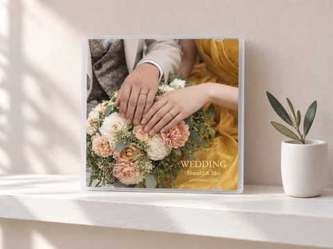 白い棚に立てた、結婚式の写真を印刷したケース